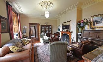 a spacious living room with a large flat - screen tv mounted on the wall , surrounded by comfortable furniture at Victoria House