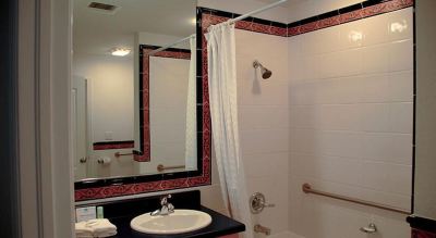 a bathroom with a black and white color scheme , featuring a sink , mirror , and shower at Wyndham Reef Resort Grand Cayman