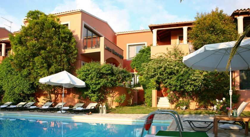 a large swimming pool is surrounded by a building with balconies and lounge chairs , with lounge chairs and umbrellas around the pool at Lena Mare Boutique Hotel