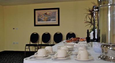 a long dining table set for a meal , with multiple cups and saucers arranged neatly at Wyndham Reef Resort Grand Cayman