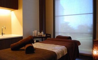 a massage room with two massage tables , one on the left and one on the right at Kawana Hotel