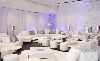 a large white room with multiple couches and chairs arranged in a seating area , creating a comfortable and inviting atmosphere at Alpha Hotel Eastern Creek