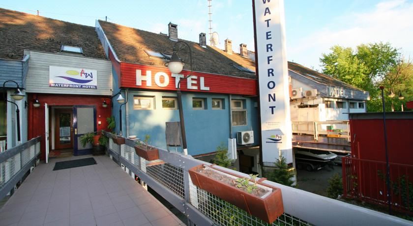 "a modern building with a red and blue sign that says "" hotel "" on it , situated near a canal" at Waterfront