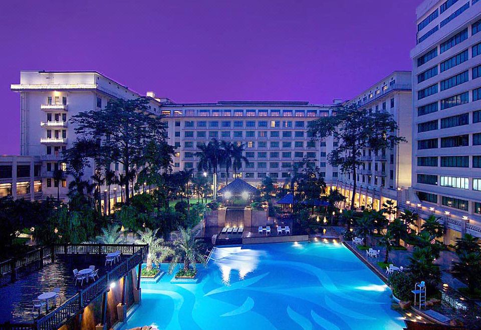 A large building with a pool in the center, surrounded by other buildings on all sides at Dong Fang Hotel