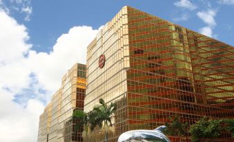 The exterior view across the street showcases tall buildings and a decorative statue in the foreground at The Royal Pacific Hotel and Towers