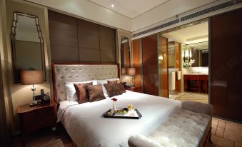 a large bed with a tray of food on it is in a room with wooden walls at Lanzhou Feitian Hotel (Lanzhou University Subway Station)