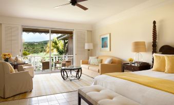 a spacious bedroom with a king - sized bed , a flat - screen tv , and a view of the ocean at Four Seasons Resort Nevis