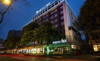 At night, the hotel building is illuminated by neon lights in the front at Howdy Smart Hotel (Chengdu Chunxi Taikoo Li)