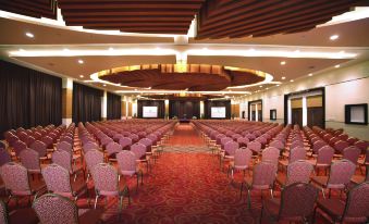 a large conference room with rows of chairs arranged in a semicircle , ready for an event at Atria Hotel Malang