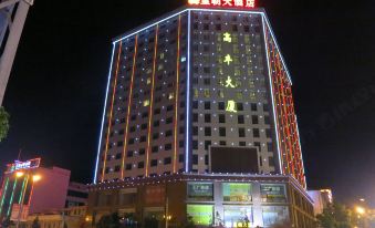 a tall building with bright lights on its facade and chinese characters written in red at Dynasty Hotel