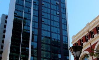 a tall building with a red brick building in front of it , located in a city setting at Pegasus Apart'Hotel